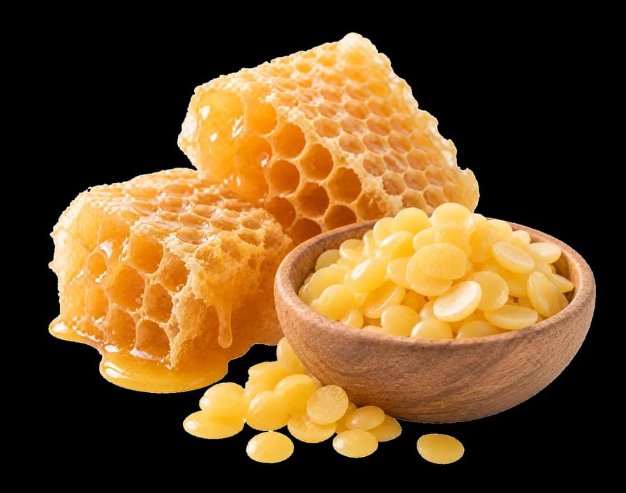 Slabs of honeycomb beside a wooden bowl of beeswax pastilles